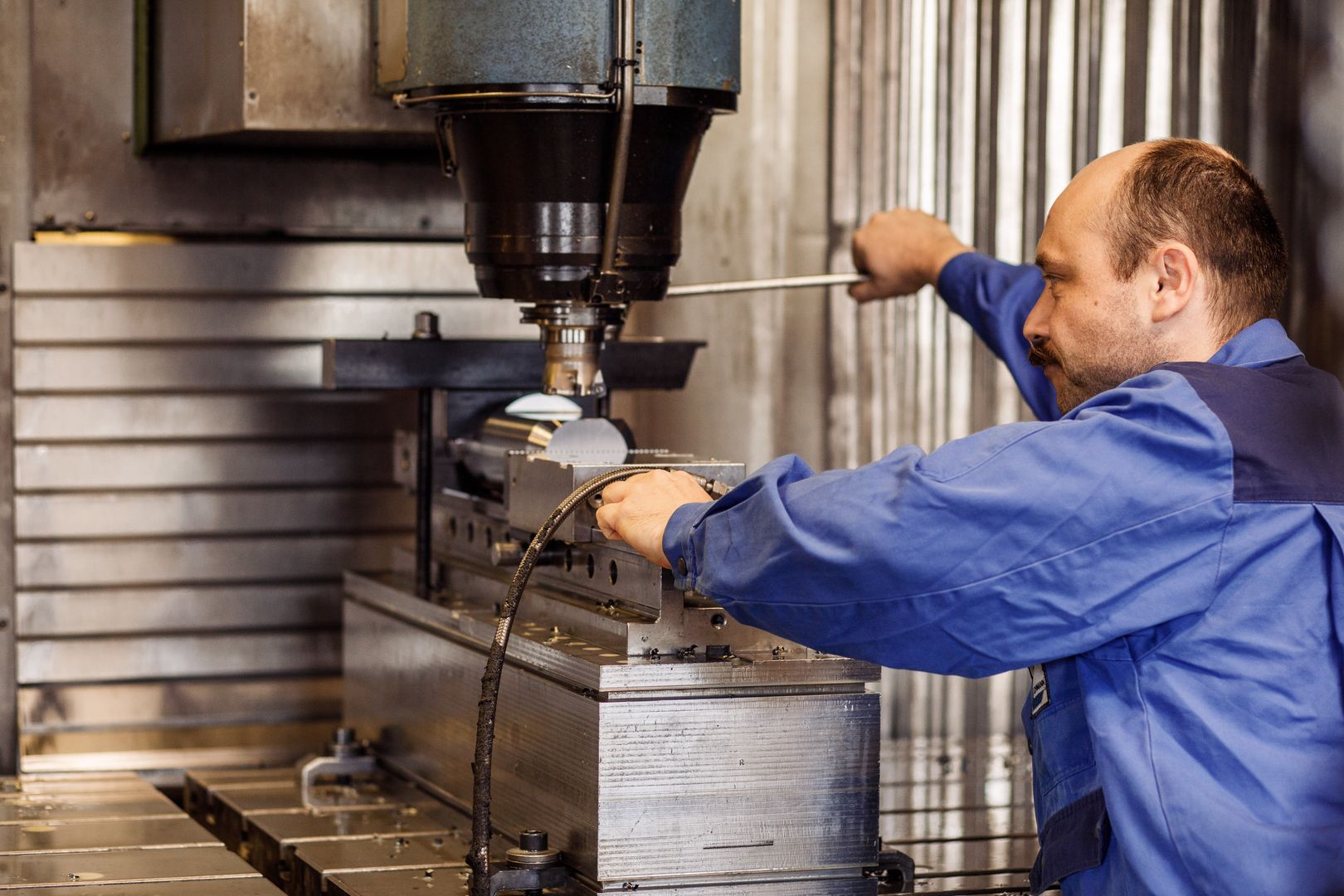 Eine Person betreibt eine CNC-Maschine